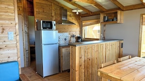 A compact kitchen with a microwave, refrigerator, and wooden counter. - La Tamarissière Village  (Agde)