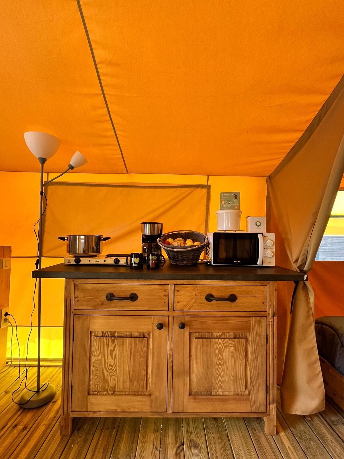 Une cuisine de taille réduite, équipée d’une cuisinière, d’un four à micro-ondes et d’un petit évier.