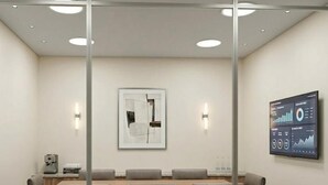 A conference room with a long table, four chairs, a projector screen displaying graphs, and two wall-mounted light fixtures. - Pérola Suítes Boutique Hotel (Luanda)