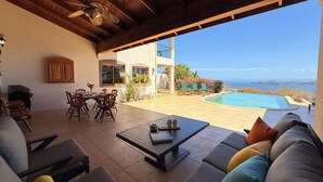 An outdoor patio with a pool, seating, and a view of the ocean. - Oceanview Luxury Villa in Playa Hermosa | 4 BR - 4.5 Baths & Private Pool (Playa Hermosa)