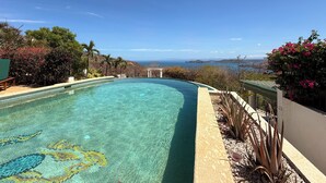 A clear swimming pool with a view of the sea and hills. - Oceanview Luxury Villa in Playa Hermosa | 4 BR - 4.5 Baths & Private Pool (Playa Hermosa)