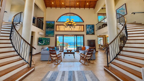A spacious interior with a grand staircase, a dining area, and large windows offering a view. - Oceanview Luxury Villa in Playa Hermosa | 4 BR - 4.5 Baths & Private Pool (Playa Hermosa)