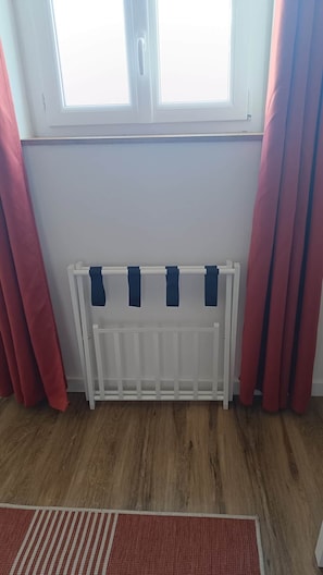 A room with a white radiator, red curtains, and a wooden floor. - defaultName (Songeons)