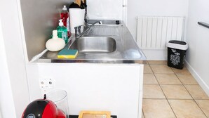 A compact kitchen with a sink, microwave, and window.