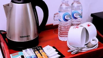 Ein Tablett mit einem Edelstahl-Wasserkocher von INNOVEX, zwei Infinity-Flaschen, einer weißen Tasse mit Löffel und mehreren Reisekarten.