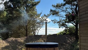 A hot tub with steps, surrounded by trees and a clear sky. - Woodland get away 0.7 mile walk from the beach ! (Mawgan Porth)