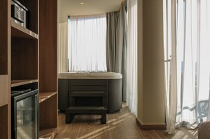A modern bathroom with a bathtub, a shower area, and a toilet.