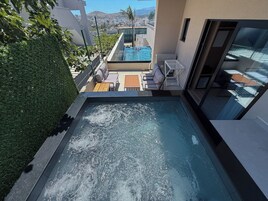 A rooftop pool with a view of a cityscape, surrounded by greenery and modern outdoor furniture.