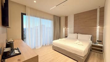 Una habitación de hotel moderna con cama, mesita de noche y televisión montada en la pared.