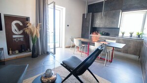 Eine moderne Küche mit Essbereich, einer Couch und einem großen Fenster.