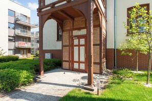 Ein Gebäude mit einem traditionellen Holzeingang, einer Ziegelwand und einem kleinen Baum.