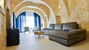 Een woonkamer met een bank, een bijzettafeltje en een tv-meubel.