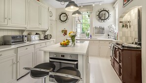 A kitchen with white cabinets, a central island, a stove, and a sink.