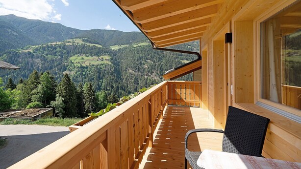 A wooden deck with a view of a mountainous landscape. - Apartment 'Marschalkhof Peilstein' with Mountain View, Shared Garden and Wi-Fi (San Pancrazio)