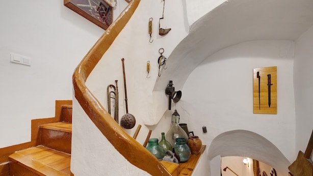 Un escalier en colimaçon avec des marches en bois et un mur blanc.