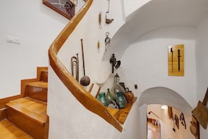 A spiral staircase with wooden steps and a white wall. - Apartment 'Can Molone' with Wi-Fi (Cornudella de Montsant)