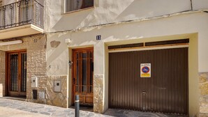 Un bâtiment aux murs de pierre, aux portes numérotées et à l’entrée grillagée.