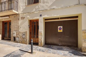 Un edificio con paredes de piedra, puertas numeradas y una entrada con rejas.