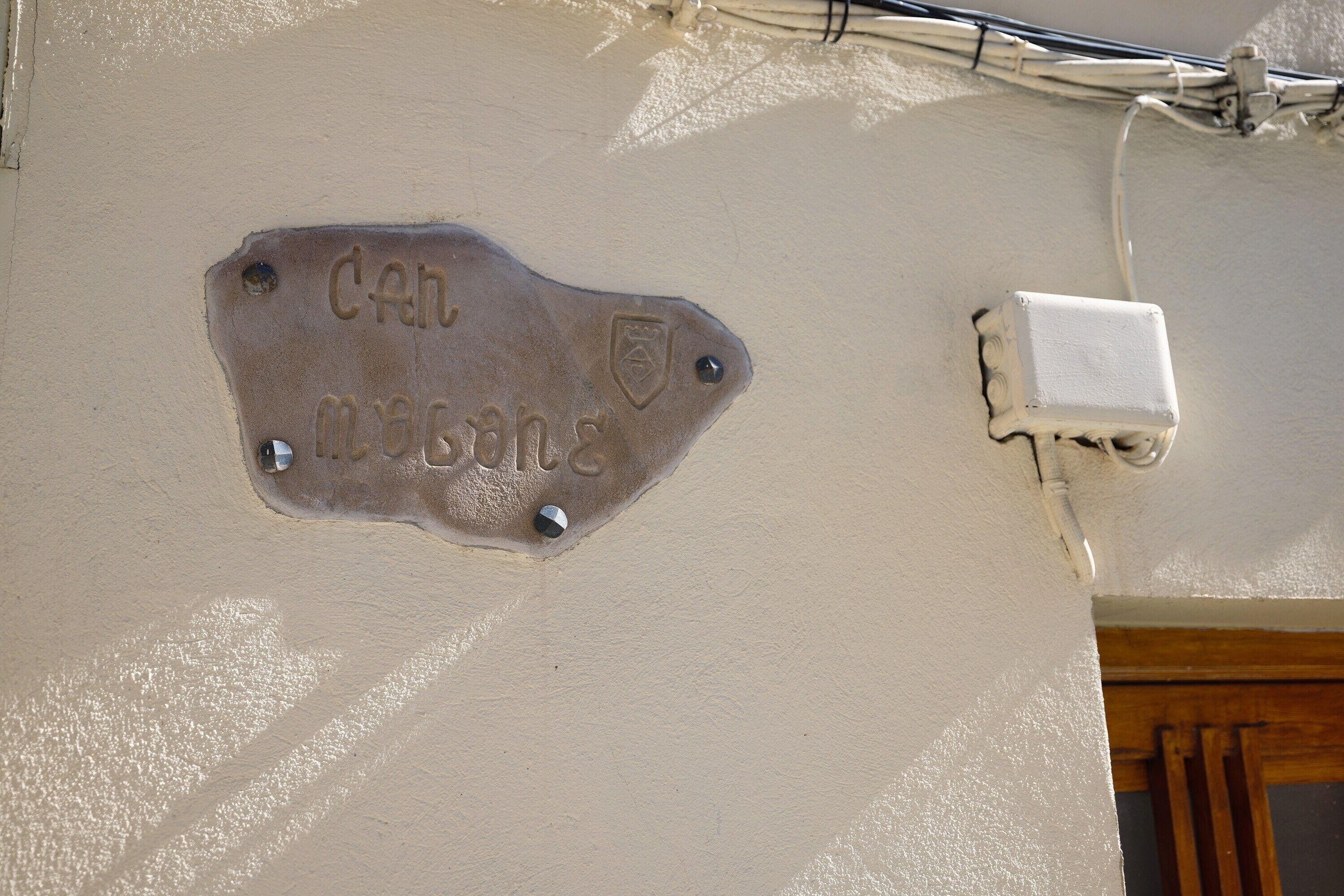 A wall-mounted plaque with the inscription 'Can Magsang' and a small white electrical box.