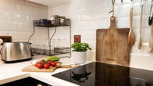 Een moderne keuken met een roestvrijstalen waterkoker, een houten snijplank en een houten snijplank met de tekst 'kaas'.