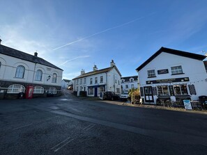 A street with white buildings, a red telephone booth, and a shop named 'The Honeypot'. - Craftsman's Loft (Hawkshead)