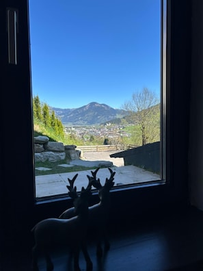 Ein Fenster mit Blick auf einen Berg und eine Stadt.