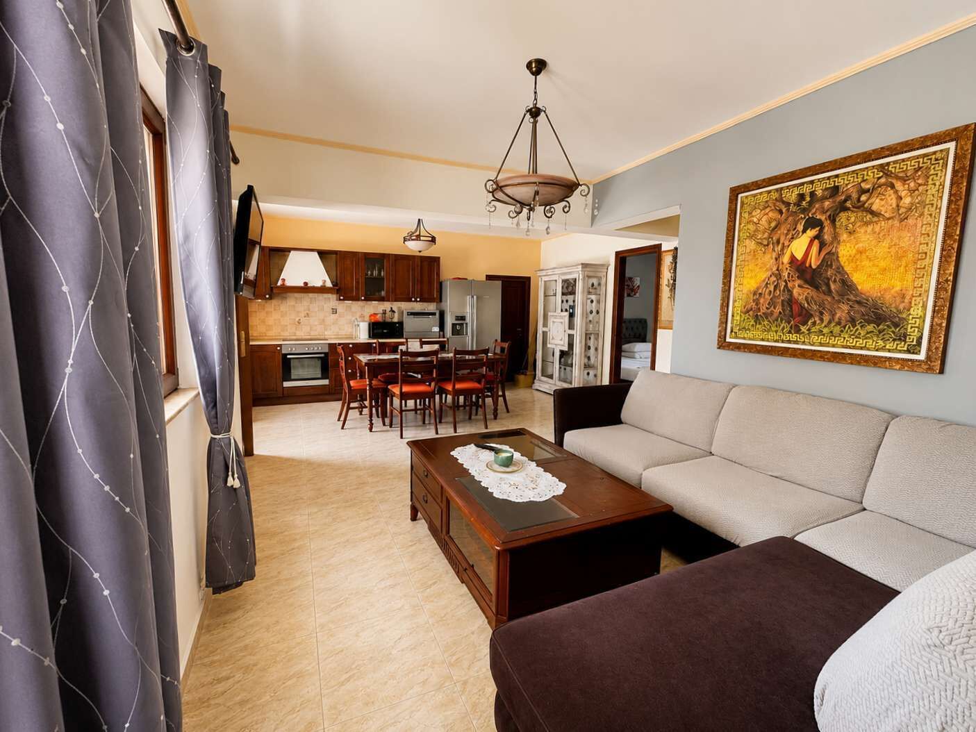 A living room with a sofa, a coffee table, and a dining area with chairs and a table.