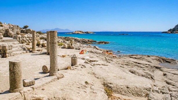 Ancient ruins with stone columns and steps, a sandy beach, and a clear blue sea. - Sunny Retreat - Kefalos Stay with Patio & Parking (Kamari)
