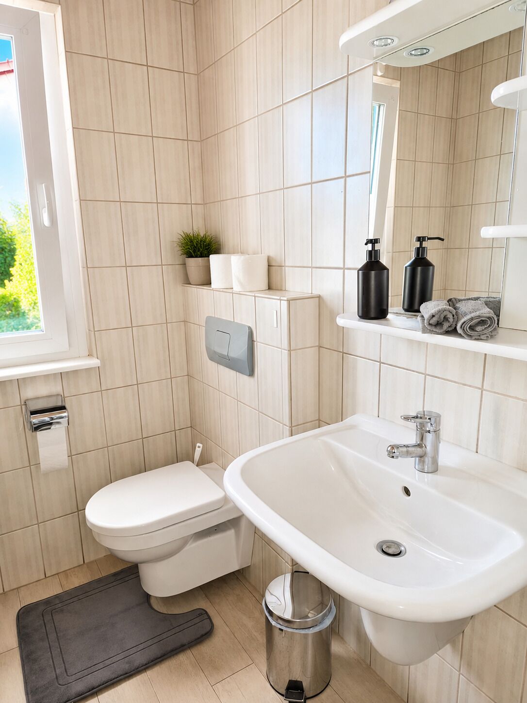 Ein modernes Badezimmer mit Toilette, Waschbecken und Spiegel.