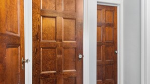 A wooden door with a white frame, a door handle, and a keyhole. - Central-Immaculate-Parking-Fenced Yard-Dining (Fort Wayne)