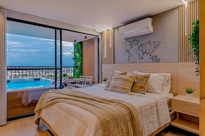 A modern bedroom with a large bed, a view of a swimming pool, and a world map on the wall. - Edificio Habitare Cristales (Cali)