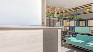 Un interior moderno con mostrador de recepción, zona de estar y una pared de acento de piedra.