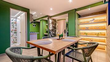 A dining area with a wooden table, four chairs, and a decorative wall with shelves.