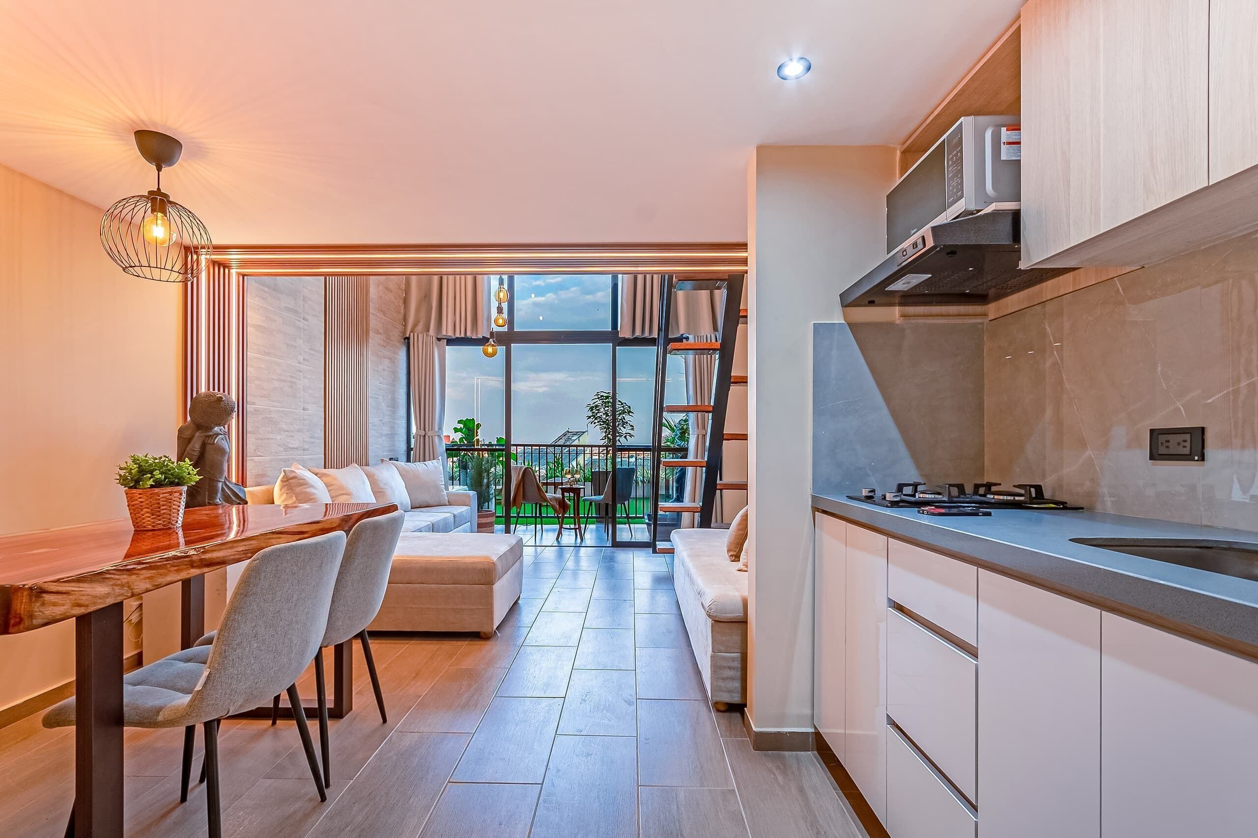 A modern kitchen with a built-in oven and a dining area with a wooden table and chairs.