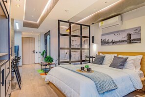 Una camera da letto moderna con un letto grande, un dipinto con vista sulla città e una parete divisoria in vetro.