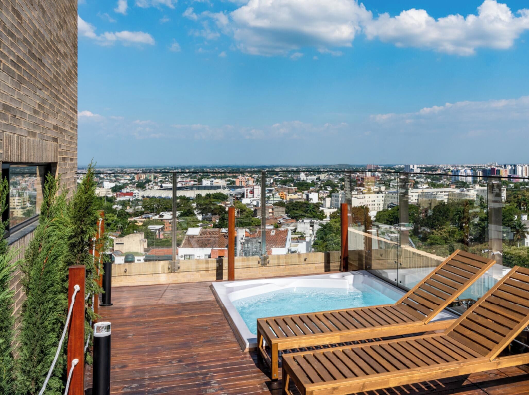 Une terrasse sur le toit, dotée d’un jacuzzi et de chaises longues, offrant une vue panoramique sur la ville.