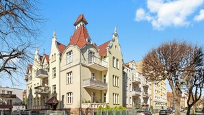 Un edificio a più piani con balconi, un tetto in tegole rosse e un ingresso con cancello.