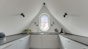 Una cucina moderna con isola centrale, una finestra e luci a sospensione.
