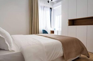Ein Hotelzimmer mit einem Bett, einem Holzregal und einem Fenster mit Vorhängen.