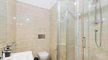 Een douche, een bidet, handdoeken, shampoo