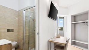 Et moderne badeværelse med brusekabine i glas, toilet og vask.