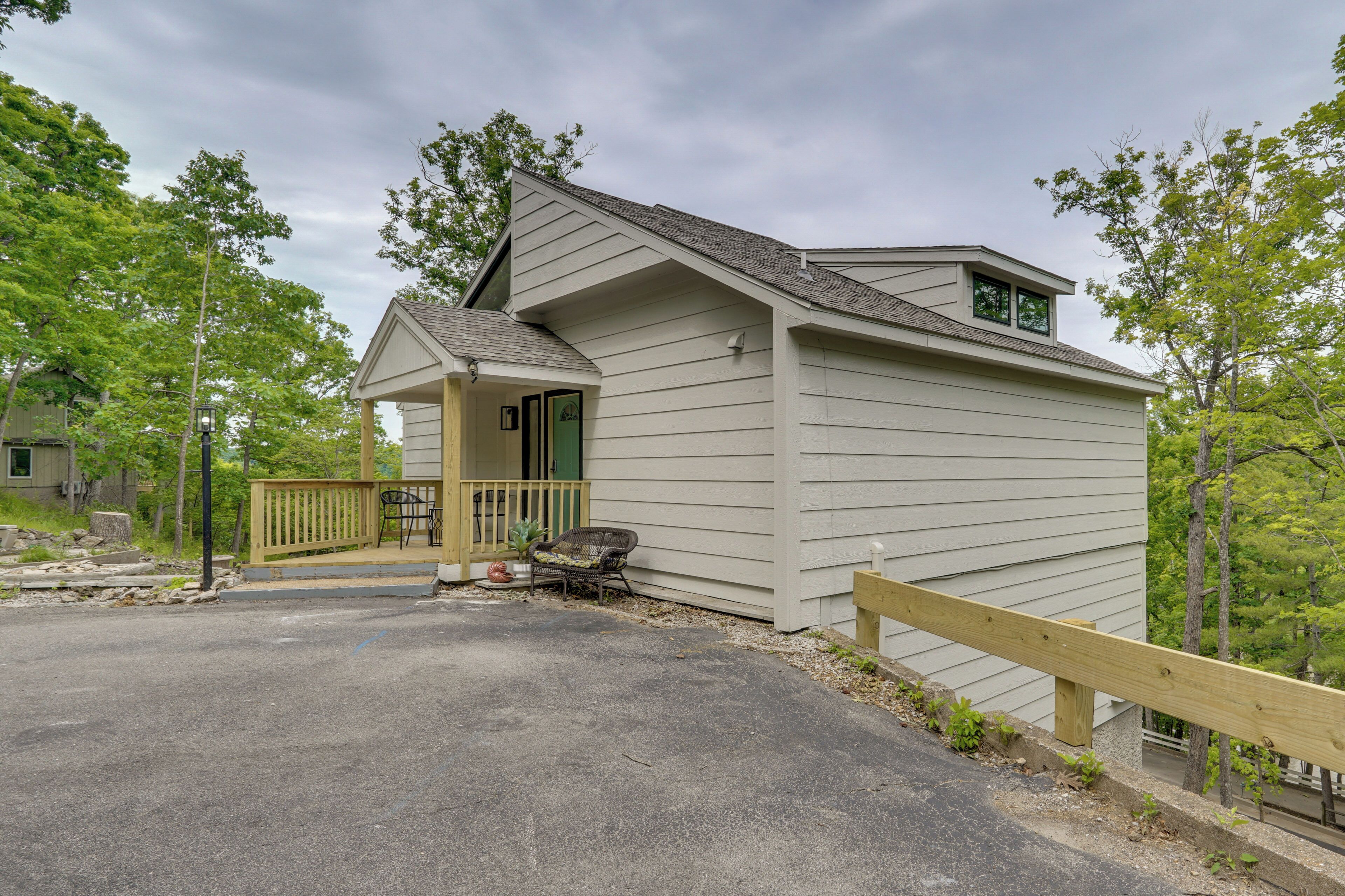 A single-story building with a porch, a small deck, and a wooden fence.