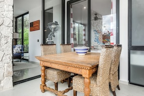 Un coin repas avec une table en bois, des chaises en osier et un bol décoratif.