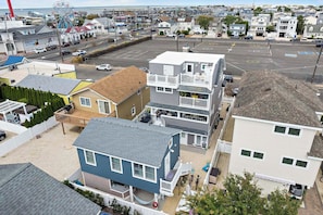 A residential area with houses, a parking lot, and a Ferris wheel in the background. - Walk to Bay Village, Beaches & More! Cozy Cottage (Beach Haven)