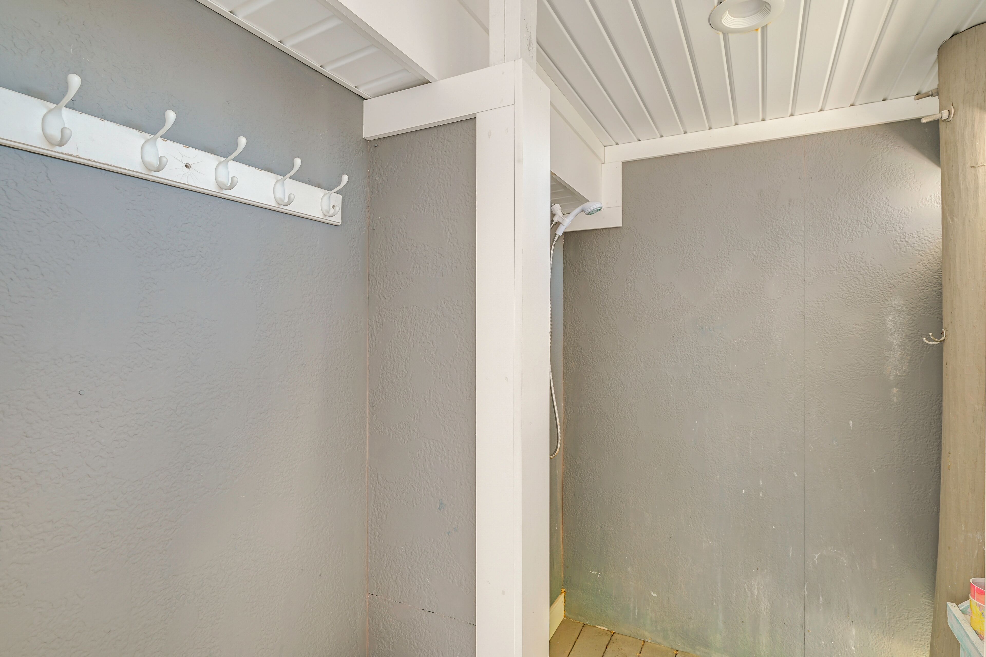 Un baño con techo blanco, toallero y zona de ducha.