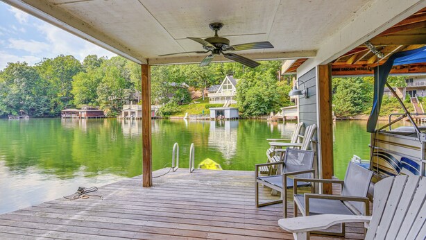 A wooden deck with chairs, a pool, and a house in the background. - Waterfront Lake Lure A-frame w/ Dock & Scenic Deck (Lake Lure)