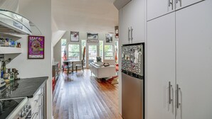 A modern kitchen with a central island, white cabinetry, and a dining area with a view. - Waterfront Lake Lure A-frame w/ Dock & Scenic Deck (Lake Lure)
