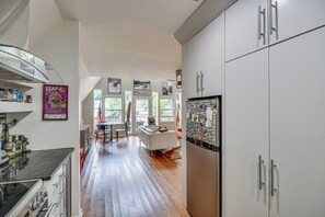 A modern kitchen with a central island, white cabinetry, and a dining area with a view. - Waterfront Lake Lure A-frame w/ Dock & Scenic Deck (Lake Lure)