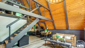 Ein geräumiges Loft mit hohen Decken, einer Treppe, einem Essbereich und einer gemütlichen Sitzecke.