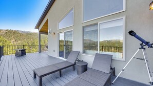 Una terrazza con poltrone relax, un telescopio e vista sulle montagne.